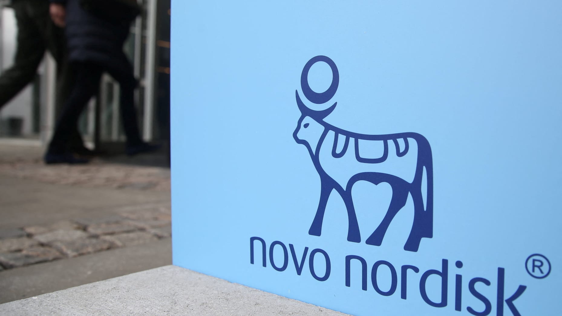 People walk past a sign for Novo Nordisk’s annual general meeting at the entrance to the venue in Copenhagen, Denmark, March 26, 2026. REUTERS/Tom Little